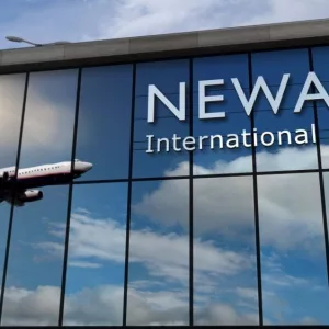 Aircraft landing at Newark^ New Jersey^ USA 3D rendering illustration. Arrival in the city with the glass airport terminal and reflection of jet plane. Travel^ business^ tourism and transport.