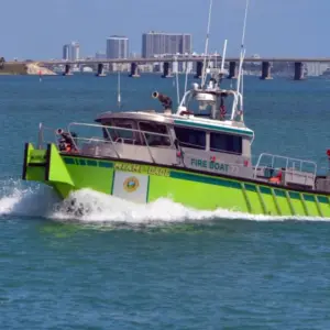 Miami-Dade fire-rescue boat patrolling on Biscayne Bay with Julia Tuttle causeway bridge in the distant background. Miami Beach^Florida^U.S.A. 13 March2021