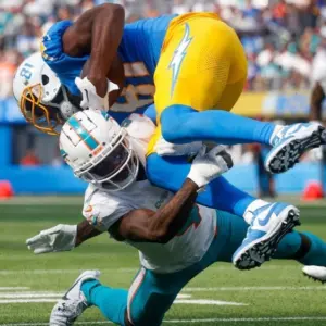 Los Angeles Chargers wide receiver Mike Williams (TOP) is brought down by Miami Dolphins cornerback Kader Kohou (BOTTOM) during an NFL football game^ Sept. 10^ 2023^ in Inglewood^ Calif.