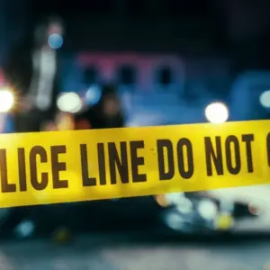 Yellow Tape Showing Text "Police Line Do Not Cross" Restricting a Crime Scene Area At Night. Close Up Aesthetic Shot with Bokeh Effect and Flickering Lights. Criminal on the Loose Strikes Again