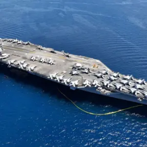 Aerial drone photo of USS Gerald R. Ford latest technology nuclear powered aircraft carrier anchored in deep blue open ocean sea