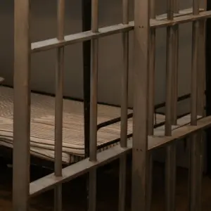 bed-in-jail-cell-with-door-in-front