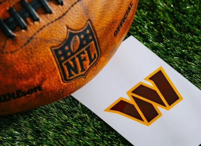Washington Commanders NFL team Logo and American football ball on Green Grass.