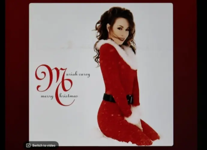 Mariah Carey's classic holiday album Merry Christmas from Spotify's interface on an Apple iPad. The currently selected track is "All I Want for Christmas Is You".