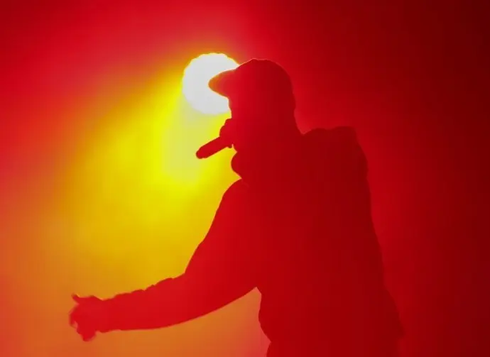 Silhouette of rap singer with microphone in hand. Rapper performing on concert.