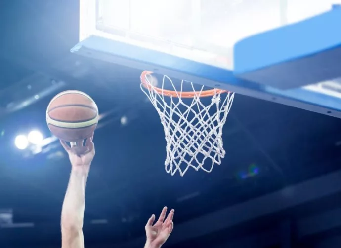 Ball in hoop at basketball game. Athletic competitions and games concept.