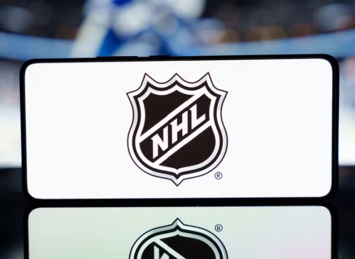A smartphone displaying the NHL logo with a blurred hockey game in the background. January 13^ 2025
