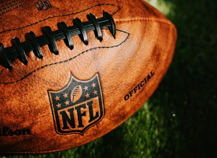 NFL background photo. Ball placed on green grass in beautiful light. NEW YORK^ USA^ SEPTEMBER 11^ 2023