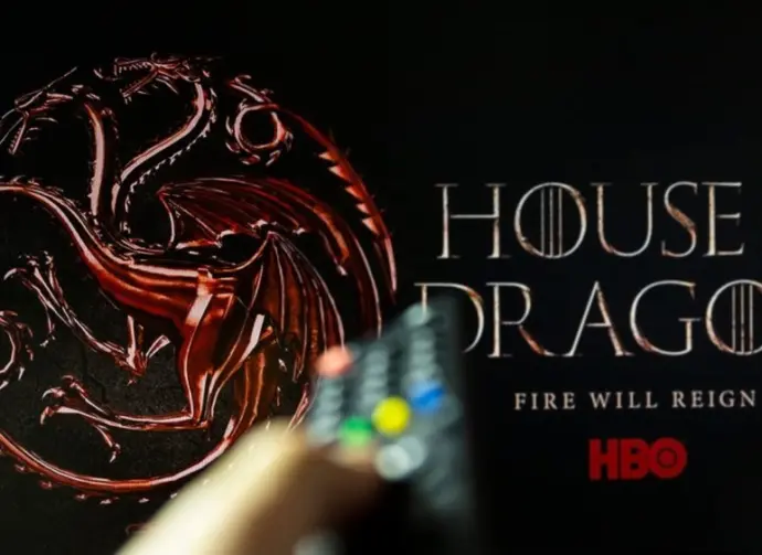 House of the Dragon HBO TV series on TV with remote control in hand. Focuse on the tv screen. Story takes place 300 years before events portrayed in Game of Thrones