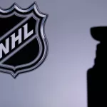 National Hockey League; Logo of NHL club on the screen. Stenley Cup Trophy Silhouette.