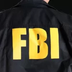 Mature FBI agent on black background^ back view