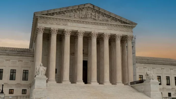 Greek classical architecture of the United States Supreme Court building with sunrise in background.