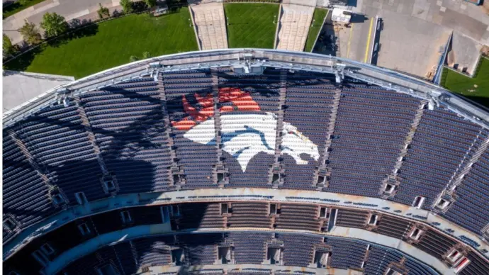 Denver Broncos Logo in Empty Stadium Seats at Empower Field. Aerial Top-Down View of NFL Branding and Architecture in Denver^ Colorado ay 26^ 2022 Denver^ Colorado