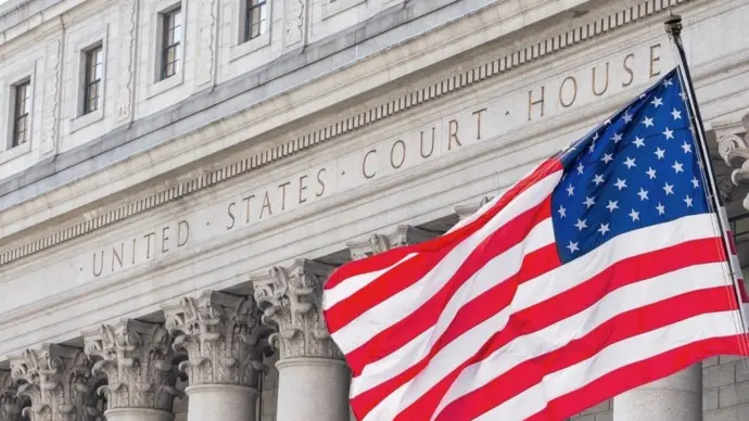 American flag waving in the wind in front of United States Court House in New York