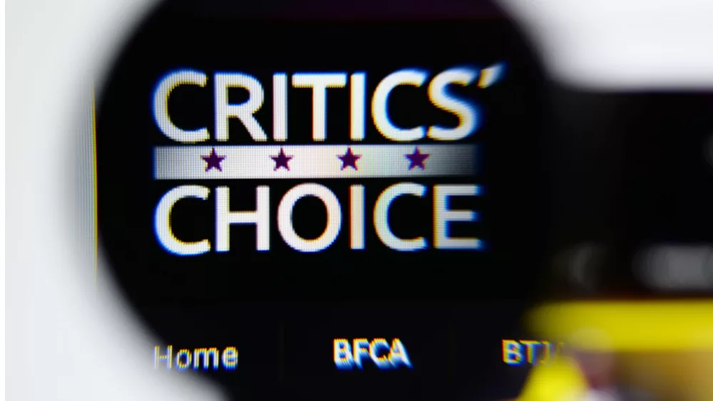 Photo of Critics' Choice Awards homepage on a monitor screen through a magnifying glass.