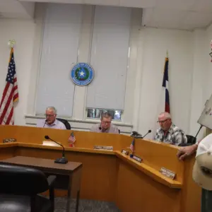 Brown County Precinct 4 Constable Michael Isbell (standing, far right) listens as Brown County Judge Tom Munson reads Isbell’s resignation letter.