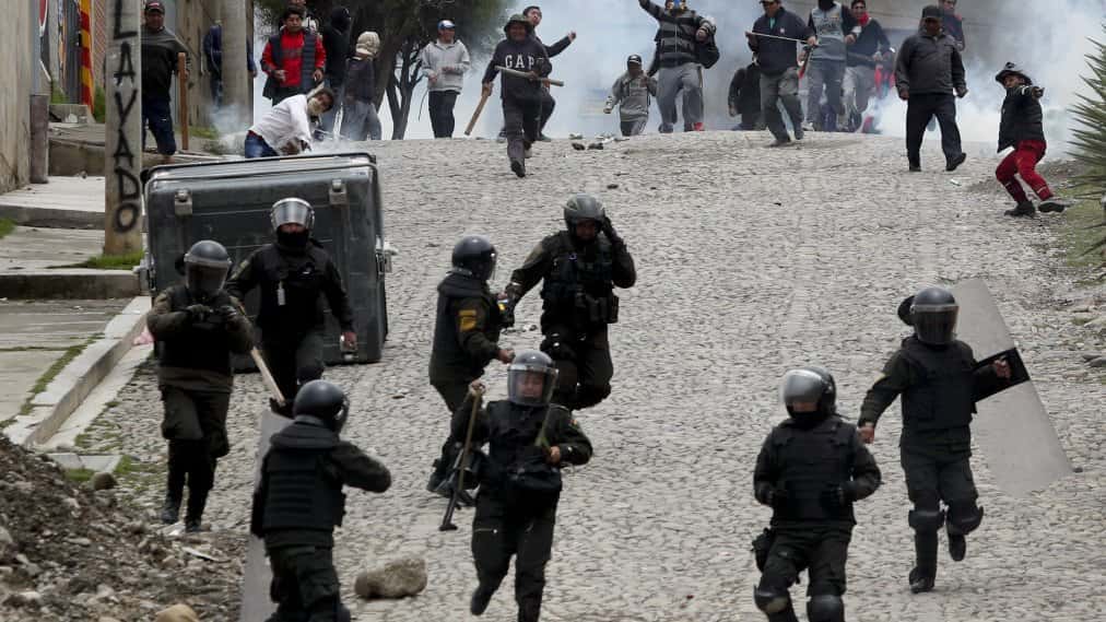 Supporters of former President Evo Morales clash with police in La Paz, Bolivia, Monday, Nov. 11, 2019. Morales' Nov. 10 resignation, under mounting pressure from the military and the public after his re-election victory triggered weeks of fraud allegations and deadly demonstrations, leaves a power vacuum and a country torn by protests against and for his government. (AP Photo/Juan Karita)