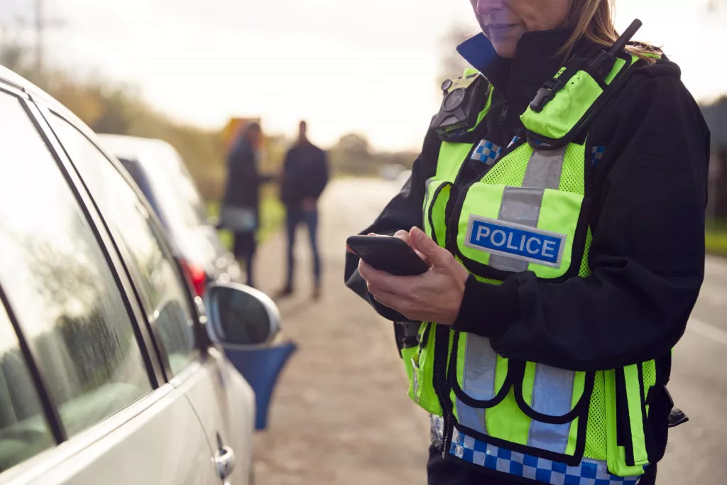 femaletrafficpoliceofficerrecordingdetailsofroadtrafficaccident