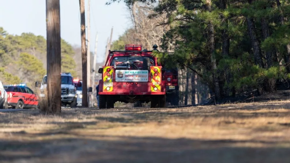 Fire company vehicles along Route 528 in Jackson^ NJ during a planned controlled burn of a section of the New Jersey pine barrens. Jackson^ NJ / USA - February 22 2020