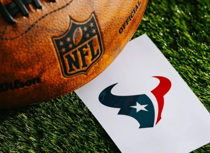 Houston Texans NFL team Logo and American football ball on Green Grass. HOUSTON^ USA^ FEBRUARY 10^ 2025
