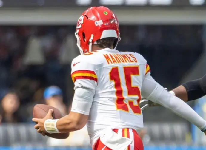 KC Chiefs quarterback Patrick Mahomes #15 runs to escape a tackle by LA Chargers outside linebacker Bud Dupree #48 during an NFL football game at SoFi Stadium^ Aug. 17^ 2024^ in Inglewood^ Calif.