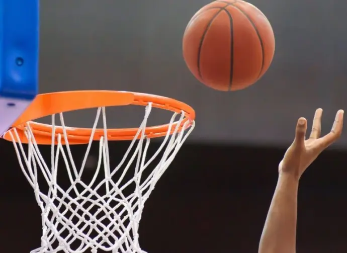 Orange basketball ball flying into the basketball hoop