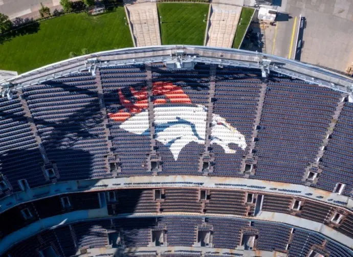 Denver Broncos Logo in Empty Stadium Seats at Empower Field. Aerial Top-Down View of NFL Branding and Architecture in Denver^ Colorado ay 26^ 2022 Denver^ Colorado