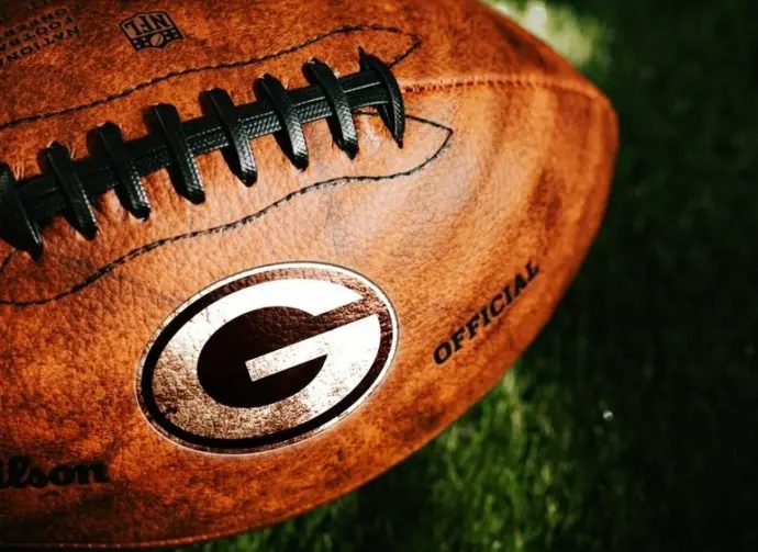 Green Bay Packers or Georgia Bulldogs NFL football Team Logo on the leather of American Football Ball