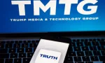 Truth Social app logo seen on the smartphone and blurred TMTG logo on the laptop.