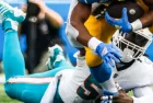 Dolphins linebacker Jerome Baker (55) tackled by Los Angeles Chargers running back Austin Ekeler (30) during an game^ Sept. 10^ 2023^ in Inglewood^ Calif.