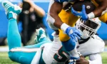 Dolphins linebacker Jerome Baker (55) tackled by Los Angeles Chargers running back Austin Ekeler (30) during an game^ Sept. 10^ 2023^ in Inglewood^ Calif.