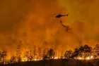 Fire fighting helicopter carry water bucket to extinguish the forest fire.