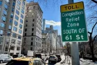 Cars driving down Fifth Avenue next to a "Toll: Congestion relief zone south of 61 Street" sign on the Upper East Side of Manhattan^ New York City New York^ NY USA - January 7^ 2025