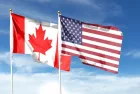 USA and Canada flags against cloudy sky. waving in the sky