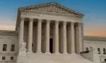 Greek classical architecture of the United States Supreme Court building with sunrise in background.