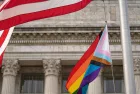 Waving Pride LGBT flag next to the flag of USA