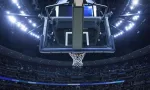Brightly lit Basketball backboard in a large sports arena.