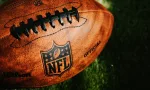 NFL background photo. Ball placed on green grass in beautiful light. NEW YORK^ USA^ SEPTEMBER 11^ 2023