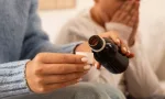 Mother giving cough syrup to her sick son in bed
