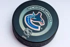 Official Vancouver Canucks game puck on the ice ^product shot