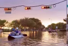 Working traffic lights over flooded Houston streets and boats with people at sunset. Texas^ USA
