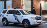 A uniformed Philadelphia Police officer stands beside a police vehicle. PHILADELPHIA^ PA - JANUARY 1^ 2015