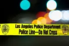 Police barricade tape with the writing 'LOS ANGELES POLICE DEPARTMENT POLICE LINE - DO NOT CROSS' illuminated night exterior with deliberately blurred background Los Angeles - January 2^ 2021