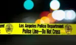 Police barricade tape with the writing 'LOS ANGELES POLICE DEPARTMENT POLICE LINE - DO NOT CROSS' illuminated night exterior with deliberately blurred background Los Angeles - January 2^ 2021