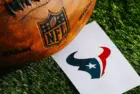 Houston Texans NFL team Logo and American football ball on Green Grass. HOUSTON^ USA^ FEBRUARY 10^ 2025