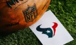 Houston Texans NFL team Logo and American football ball on Green Grass. HOUSTON^ USA^ FEBRUARY 10^ 2025