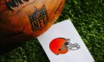 Cleveland Browns NFL team Logo and American football ball on Green Grass.