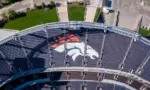 Aerial Top-Down View of Denver Broncos Logo in Empty Stadium Seats at Empower Field May 26^ 2022 Denver^ Colorado