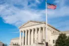 Facade of the United States Suprement Court with American flag in Washington^ DC