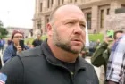 Alex Jones^ flanked by bodyguards^ leaves a rally protesting Covid-19 stay at home orders at the Capitol that was heavily promoted by his Infowars website. Austin^ Tx/USA - Apr. 18^ 2020